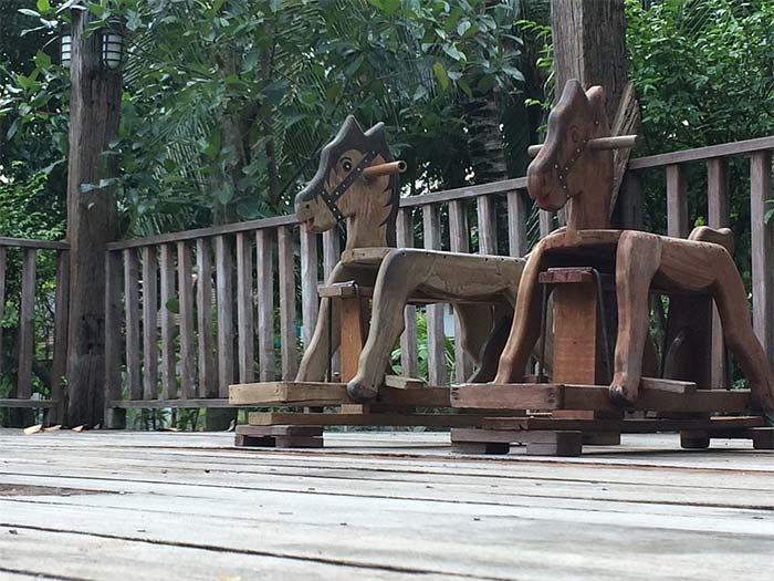 terrasse avec garde corps en bois et jouets petits chevaux en bois